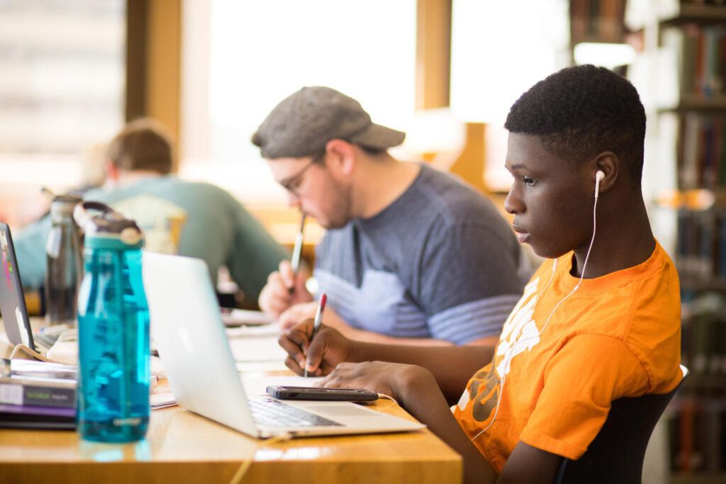 Students with laptops and notebooks study in Hodges Library